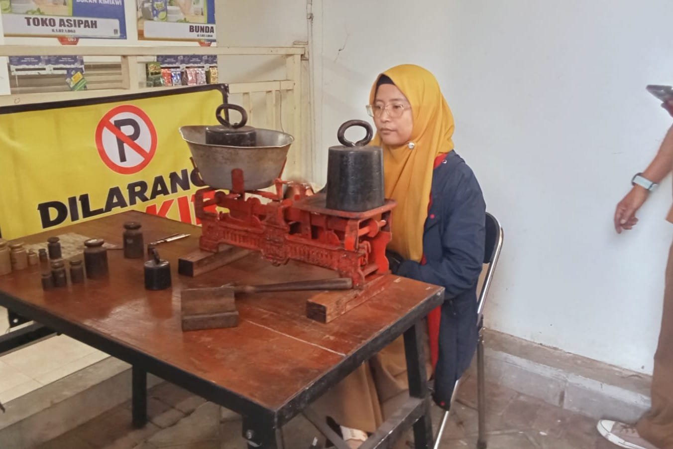 Ft.1: Petugas Tera timbangan sedang menakar keseimbangan pada timbangan milik pedagang pasar pagi di Pasar Induk Among Tani. (dok.Diskumperindag Batu)