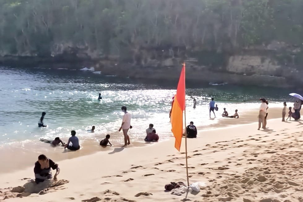 Wisatawan lokal sedang menikmati bermain pasir laut di Pantai Tanjung Penyu. (Ist)