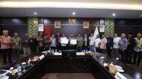 Wali Kota Batu menunjukkan Berita Acara Hasil Uji Petik (BAHUP) yang telah ditandatangani bersama unsur Hexahelix.